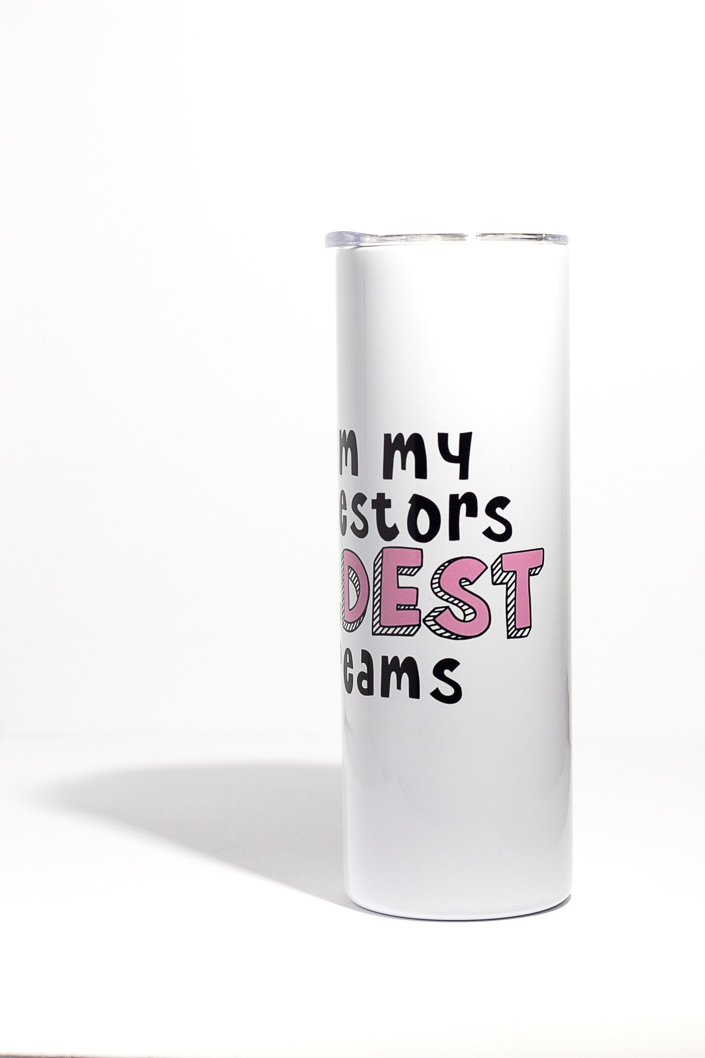 A white 20oz tumbler with "I am my ancestors wildest dreams" written in black and pink letters