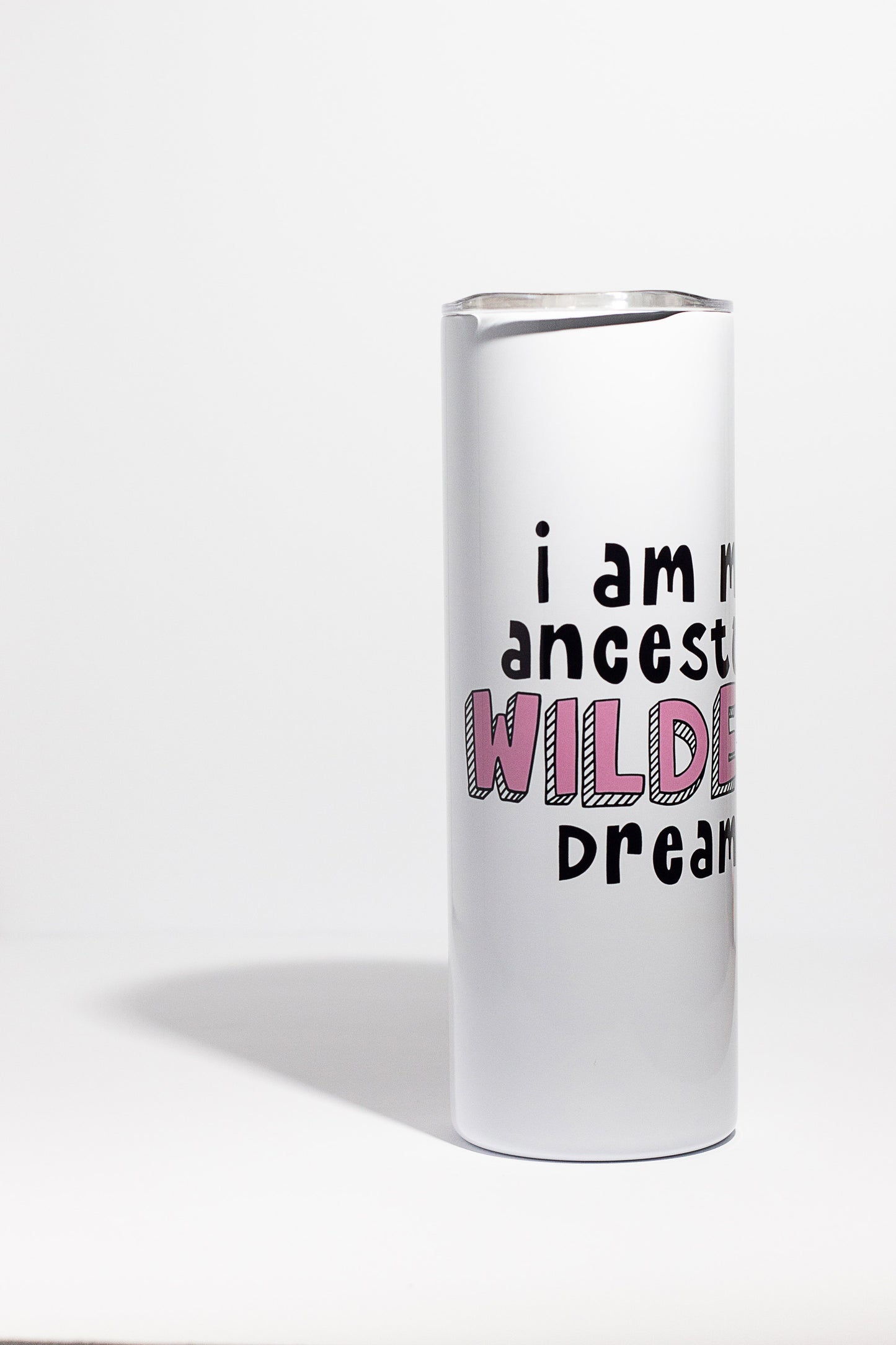 A white 20oz tumbler with "I am my ancestors wildest dreams" written in black and pink letters