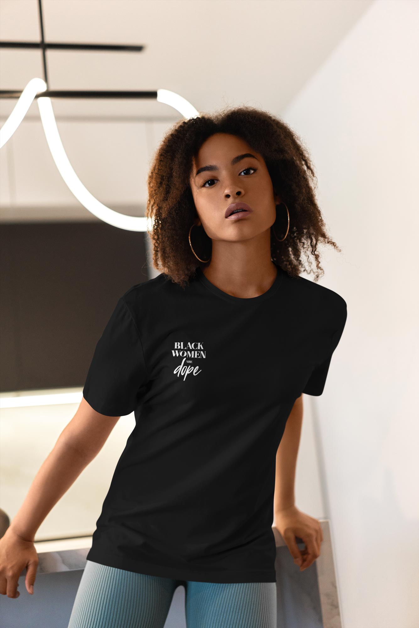 Woman in a black t shirt that has black women are dope written in white