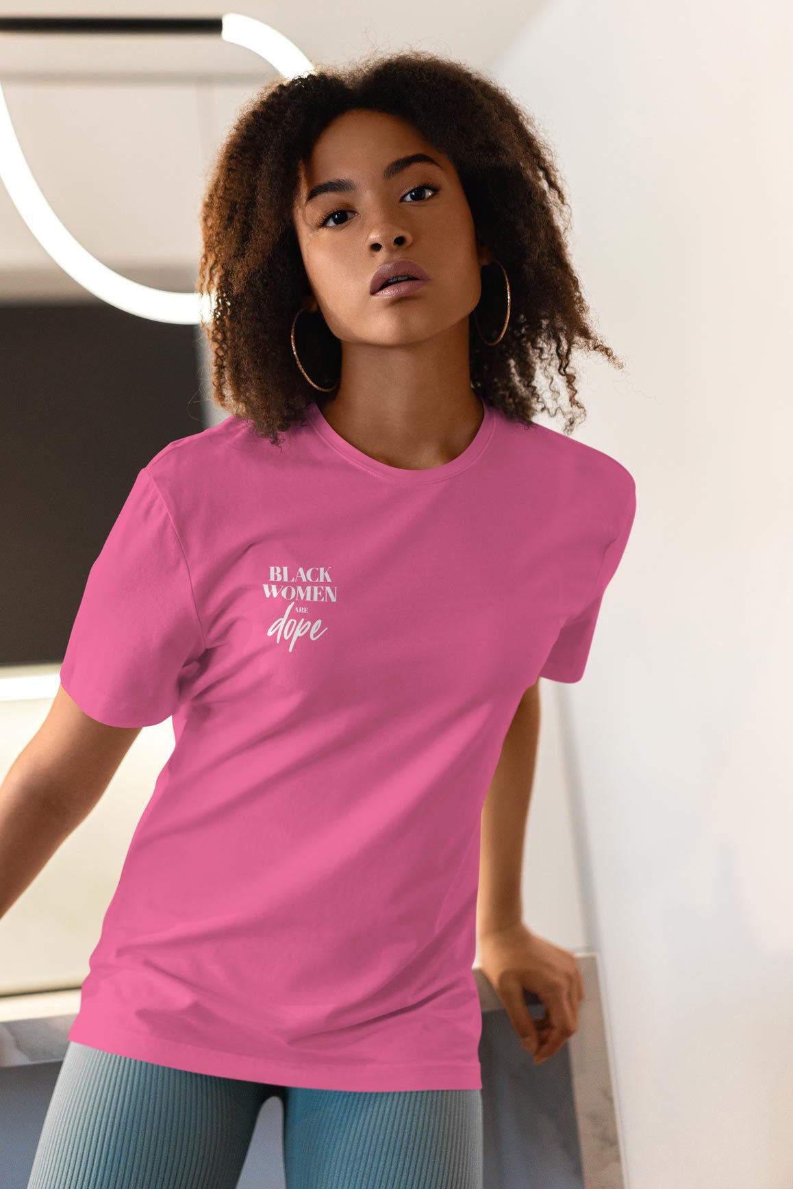 Woman in a pink t shirt that has black women are dope written in white