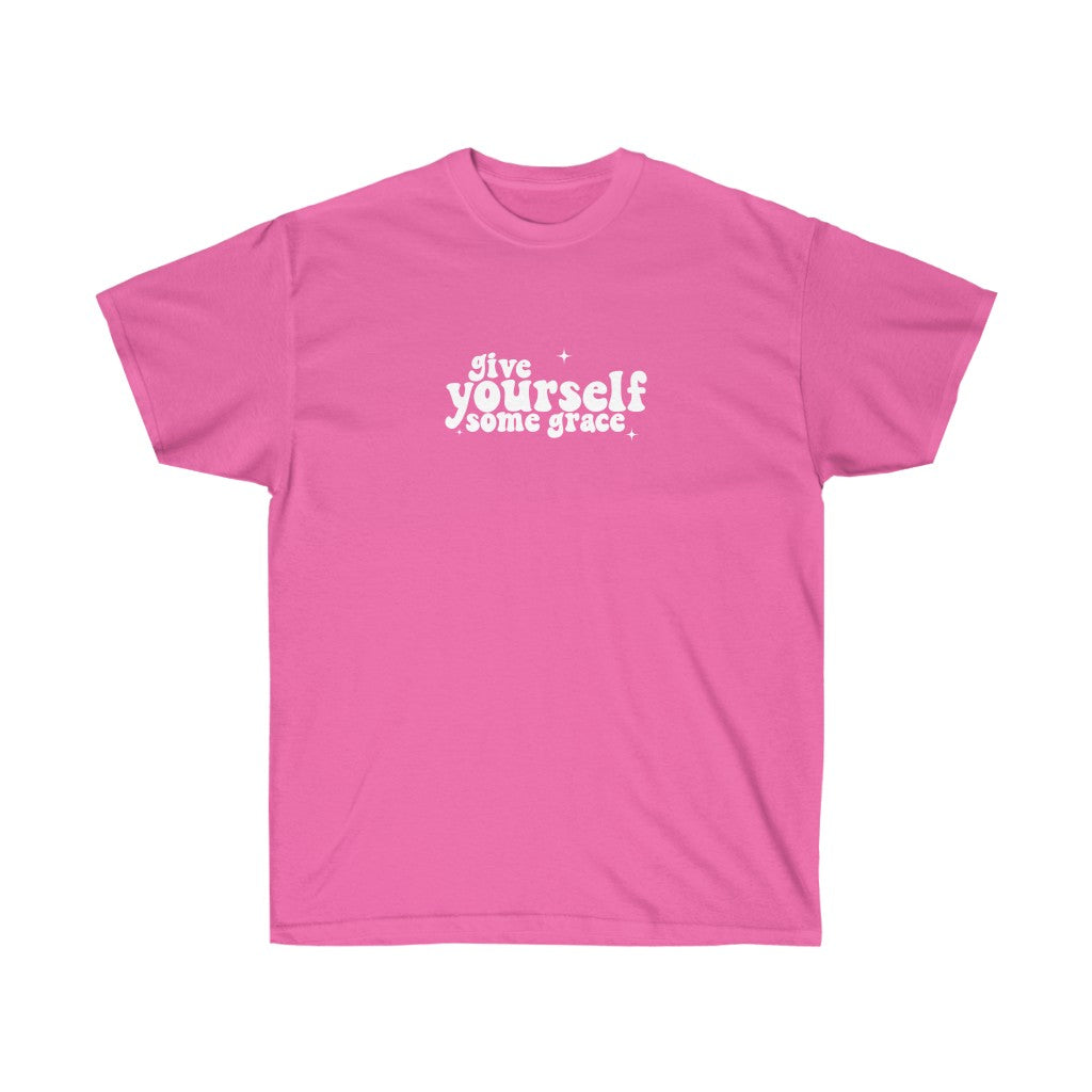 Pink t shirt that says give yourself some grace in 70s inspired retro text