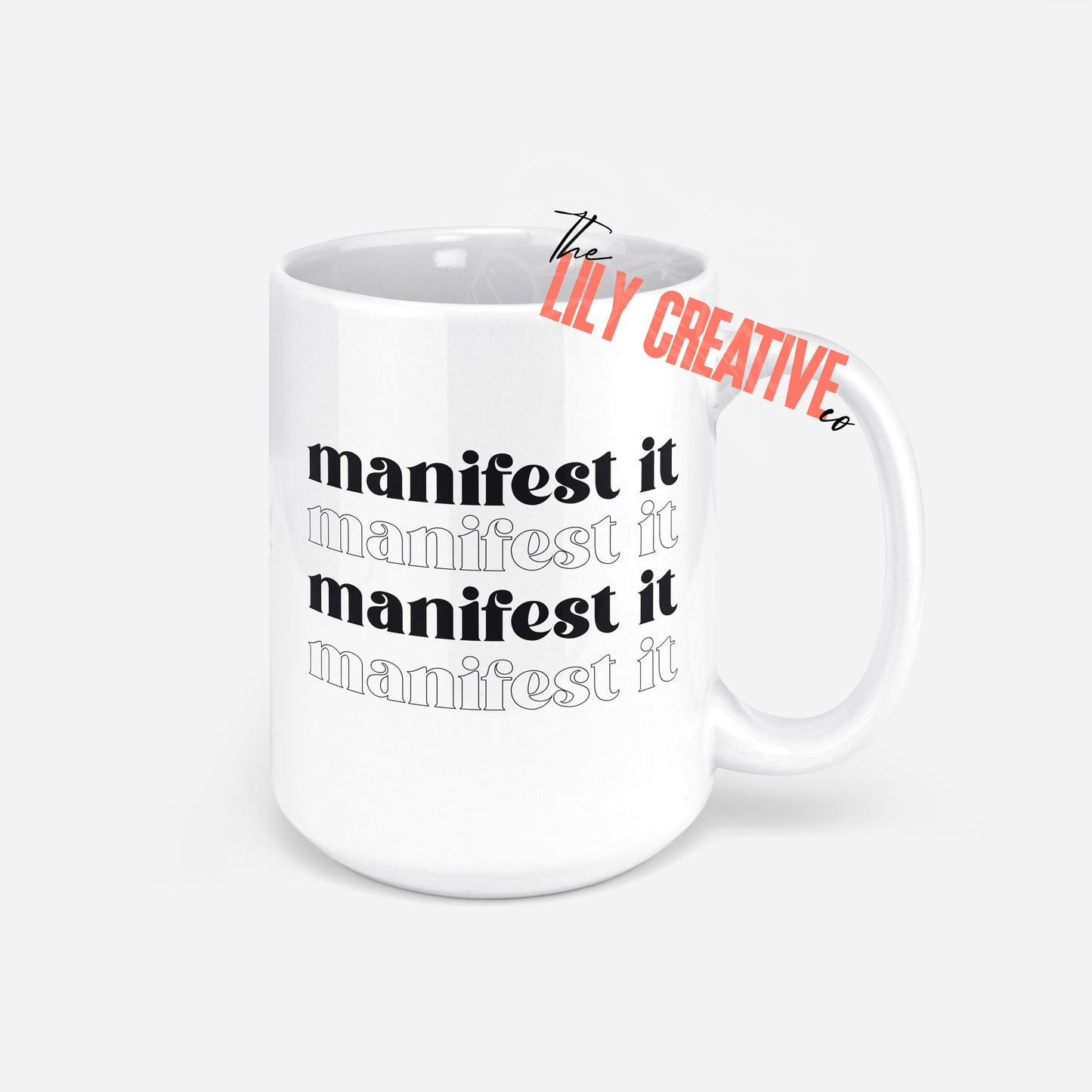 15 ounce white ceramic coffee mug that says manifest it in black ink
