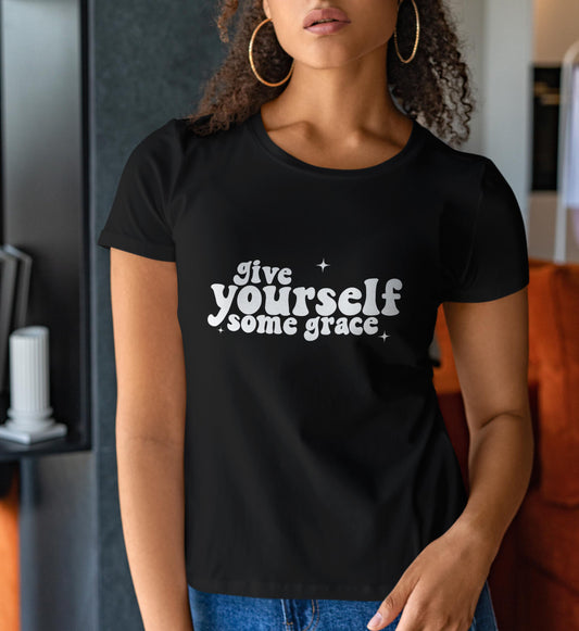 Woman in a black shirt that reads "give yourself some grace"