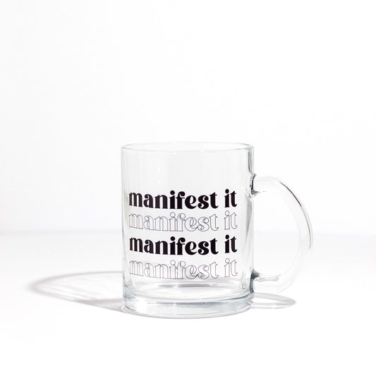 11oz clear glass mug that says "manifest it"